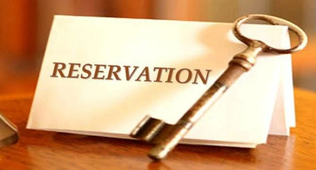 Reservation written on a white paper with a key placed on the side of the paper