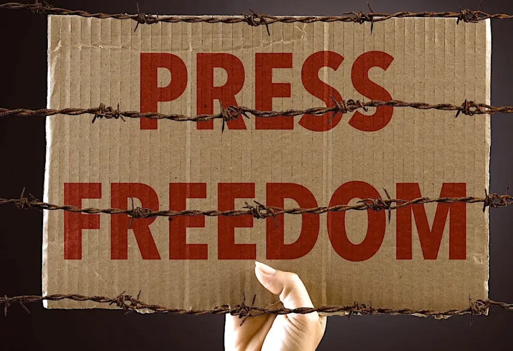 Press Freedom wrote on the cardboard held by the hand and placed behind the wire.